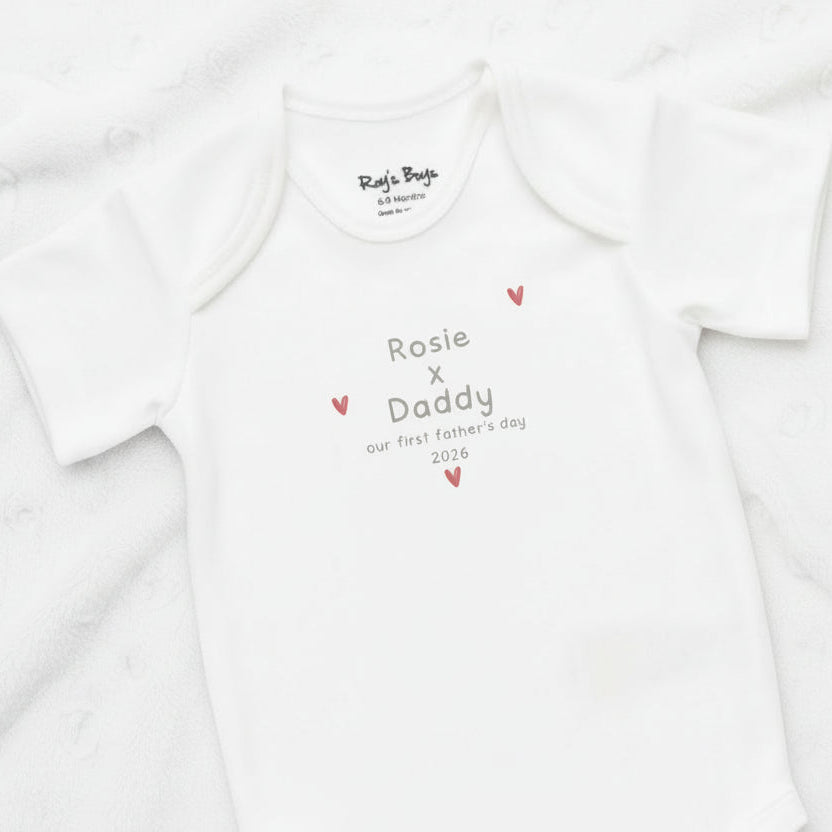 White baby onesie with personalized text on a white background