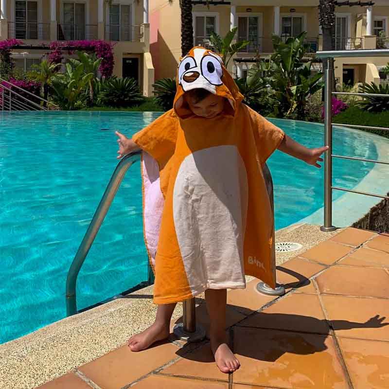 Boy in Bingo Poncho towel at the pool