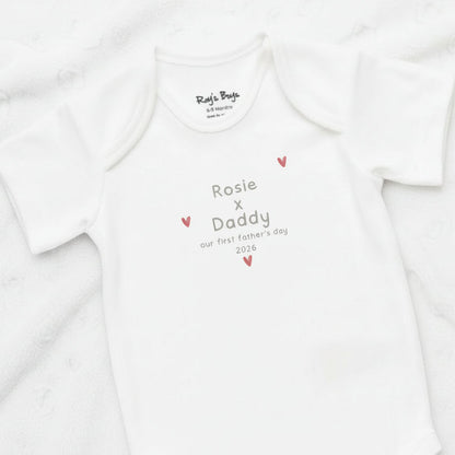 White baby onesie with personalized text on a white background