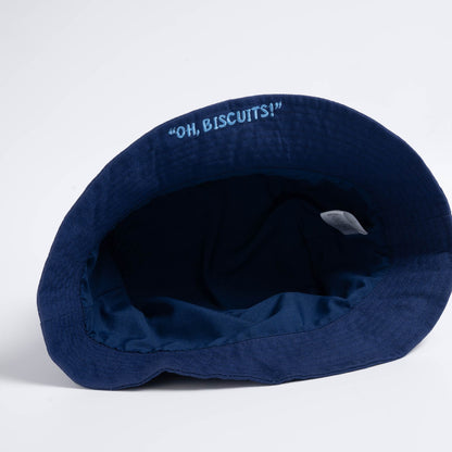 Underside of the bucket hat showing embroidered rim slogan "Oh Biscuits!"