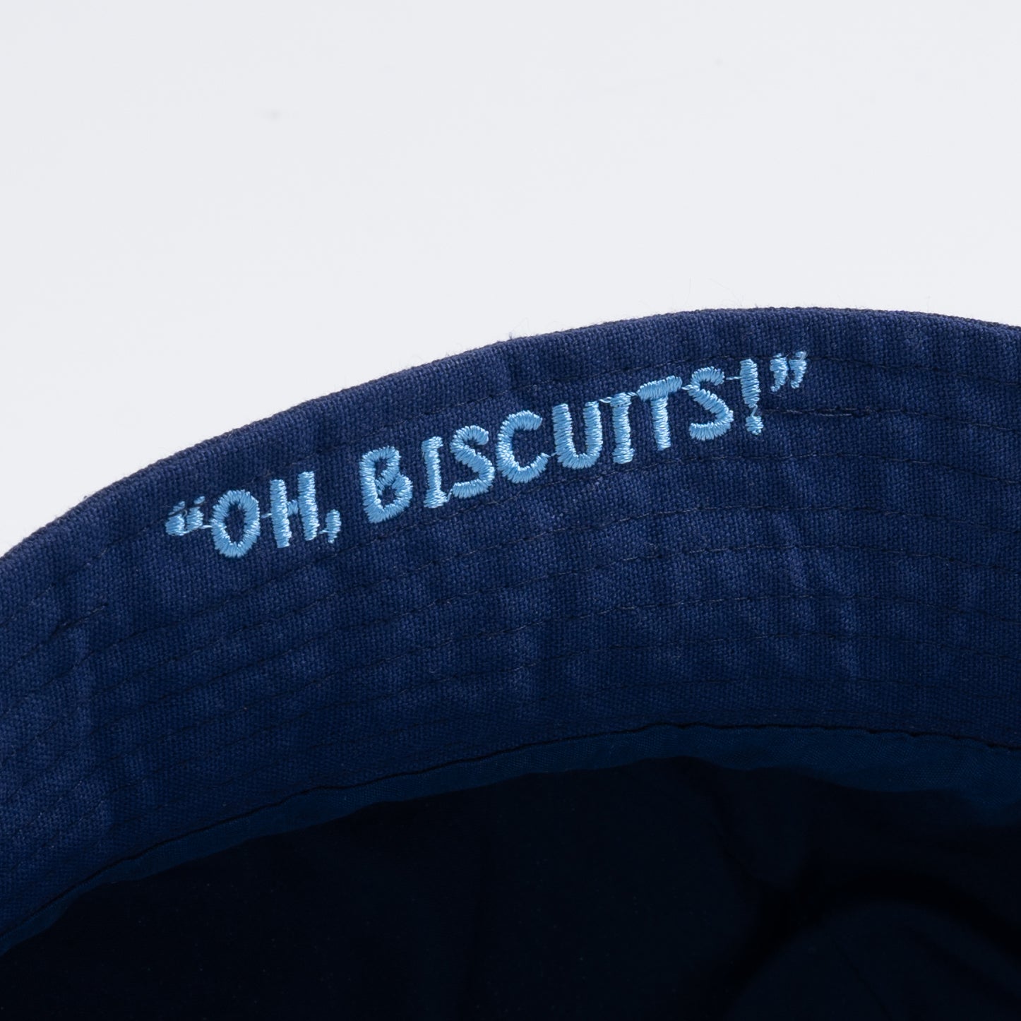Closeup of embroidered rim, reading "Oh Biscuits!"