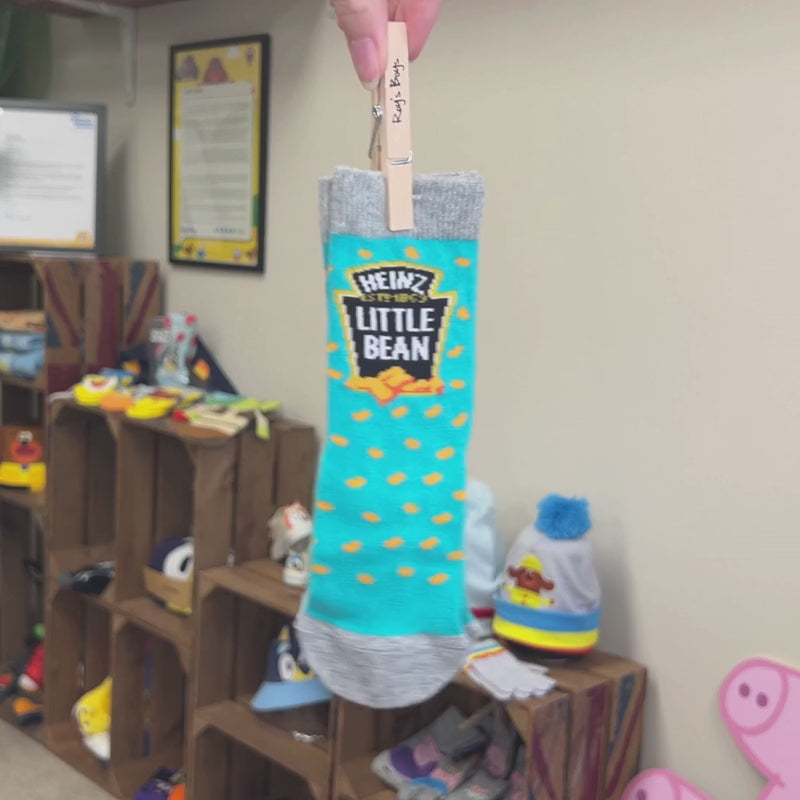 Little bean socks being swung from the wooden peg