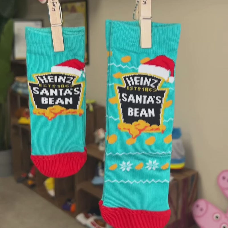 Person holding Santa bean socks by their wooden pegs