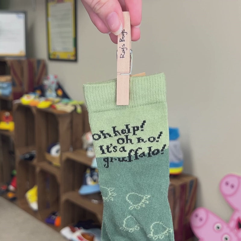 Person holding Gruffalo socks by it&