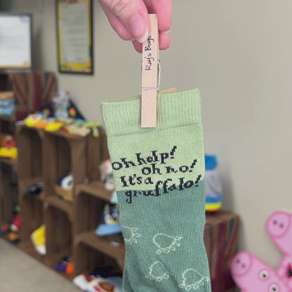 Person holding Gruffalo socks by it&