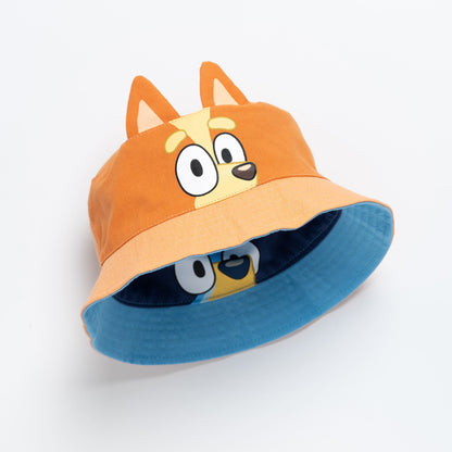 Tilted view of the kids reversible bucket hat showing the orange Bingo exterior and the blue Bluey interior
