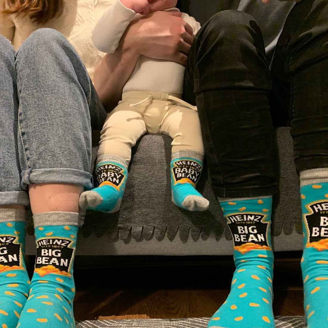 family sitting on a sofa wearing matching blue socks with the text &