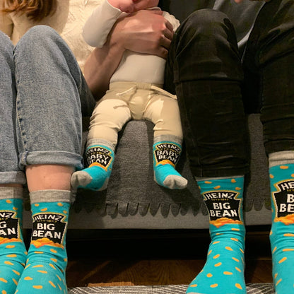family sitting on a sofa wearing matching blue socks with the text &