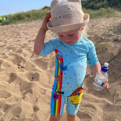 Girl at the beach in her Hey Duggee Swimsuit