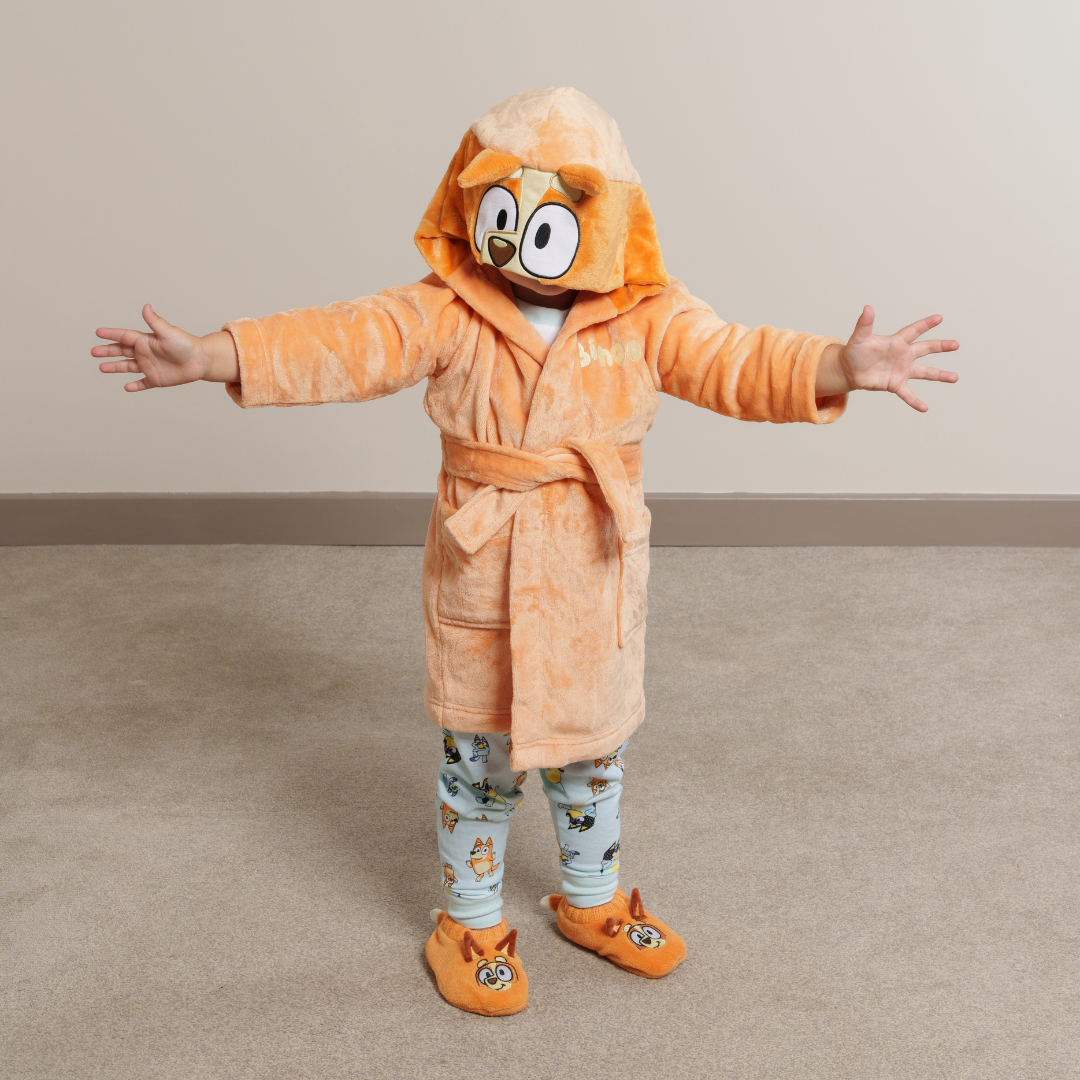 Boy wearing Bingo dressing gown, matching Bingo slipper socks and Bluey pyjamas