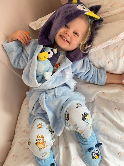 Girl wearing Bluey dressing gown, matching Bluey slipper socks and Bluey kids fam jams.